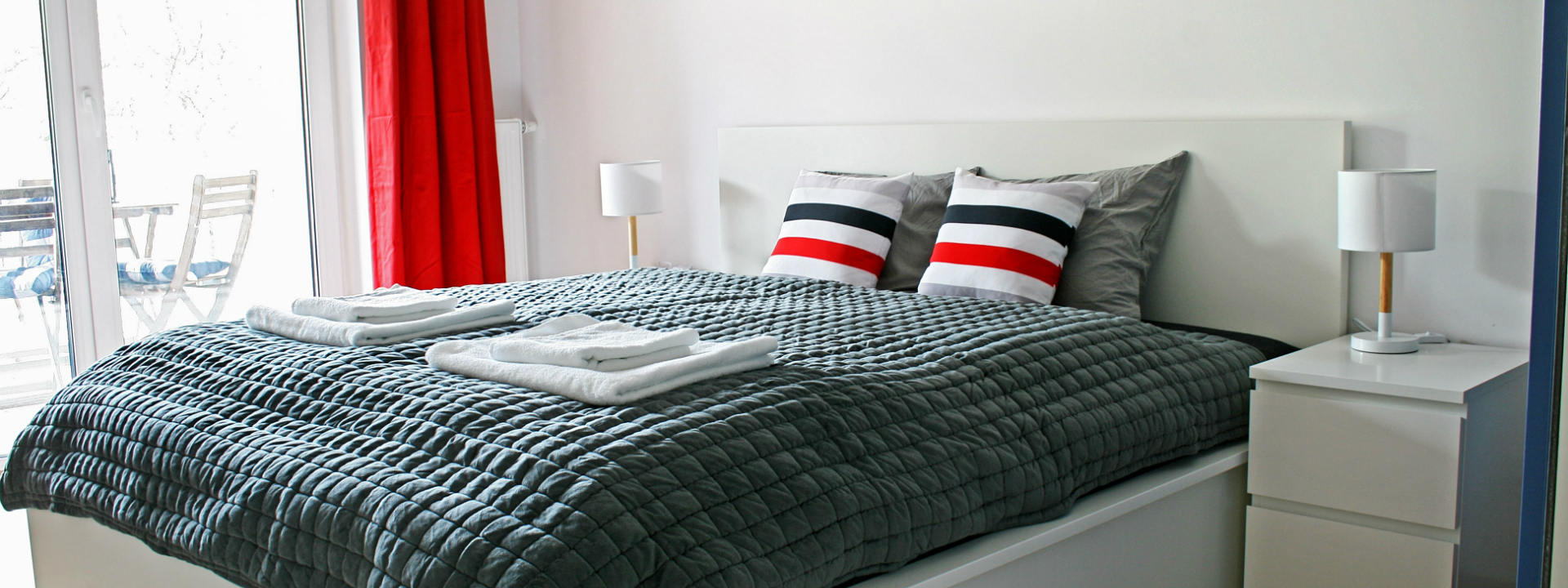Apartament Portino w Kołobrzegu – sypialnia w stylu marynistycznym z 2-osobowym łóżkiem